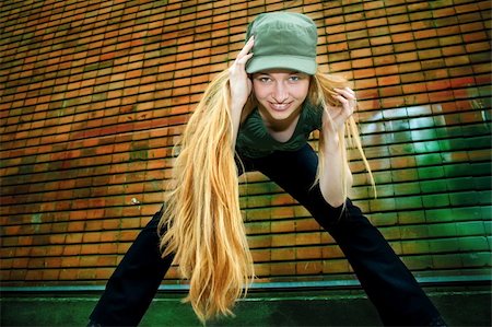 dundanim (artist) - Happy girl with long blond hair - brick wall as background Fotografie stock - Microstock e Abbonamento, Codice: 400-04069330