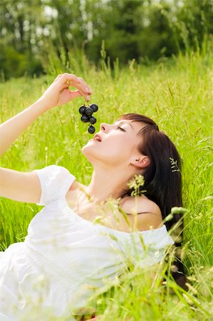 beautiful girl lying down of grass, eating black grapes Stock Photo - Budget Royalty-Free & Subscription, Code: 400-04061840