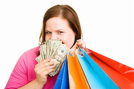 Beautiful plus sized woman with shopping bags peeking out from behind a hand full of cash. Isolated on white. Foto de stock - Super Valor sin royalties y Suscripción, Código: 400-04062399