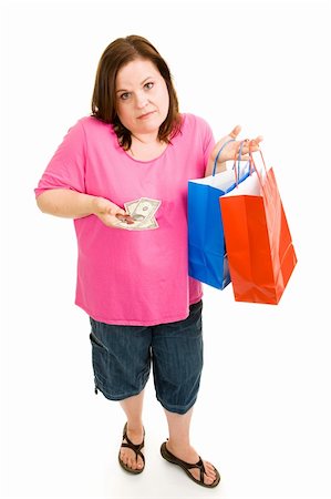 Woman holding shopping bags and looking disappointed at the small amount of change she has left over. Isolated on white. Stock Photo - Budget Royalty-Free & Subscription, Code: 400-04062391