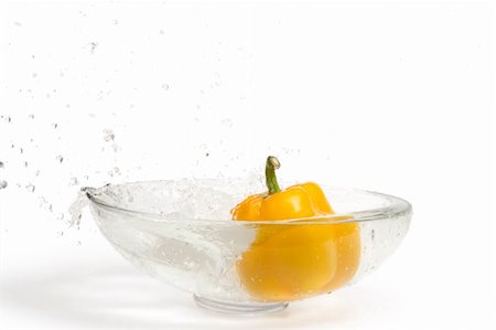 simsearch:400-07899696,k - Yellow paprika falling into glass vase with water, splashes. Isolated over white Photographie de stock - Aubaine LD & Abonnement, Code: 400-04062610