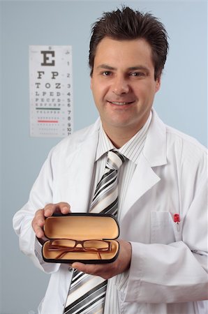 eye doctor (male) - Optometrist showing a pair of prescription eye glasses. Stock Photo - Budget Royalty-Free & Subscription, Code: 400-04063918