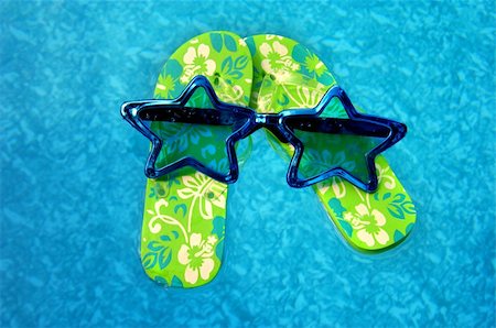 simsearch:400-08779810,k - Star shaped sunglasses float on top of a pair of flip flops. Shoes float on a background filled with aqua blue water. Stock Photo - Budget Royalty-Free & Subscription, Code: 400-04075371