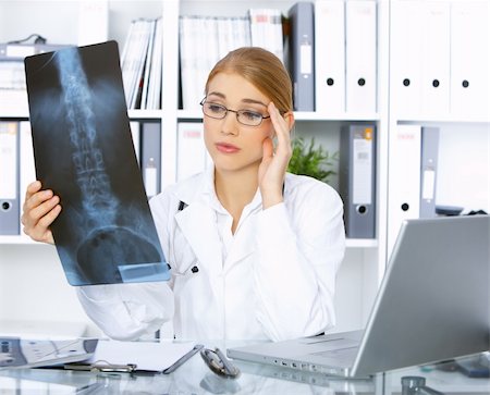 simsearch:400-04178933,k - Confused female doctor examining x-ray picture Stock Photo - Budget Royalty-Free & Subscription, Code: 400-04075540