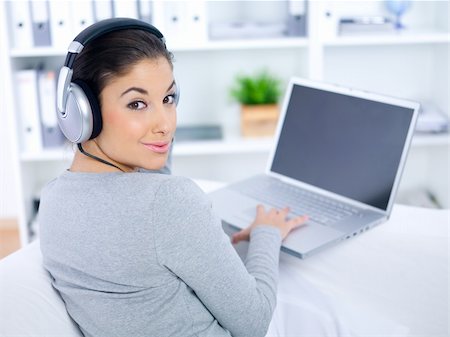 Young woman sitting on couch and working on laptop Stock Photo - Budget Royalty-Free & Subscription, Code: 400-04076234