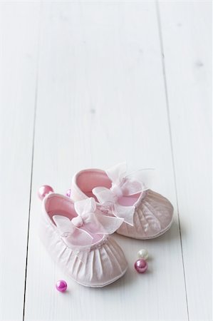 little girly baby shoes on a wooden floor, copy space for text, perfect for invitation or card Stock Photo - Budget Royalty-Free & Subscription, Code: 400-04076849