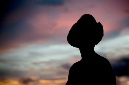 Woman in a cowboy hat silhouetted against a colorful sunset sky. Stock Photo - Budget Royalty-Free & Subscription, Code: 400-04070470