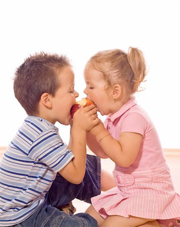 simsearch:673-02138312,k - Little boy and girl bite an apple Stockbilder - Microstock & Abonnement, Bildnummer: 400-04071637