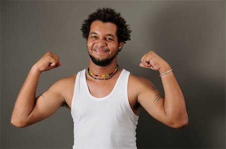 Portrait of young happy latino man showing his strong muscles Stock Photo - Budget Royalty-Free & Subscription, Code: 400-04072795