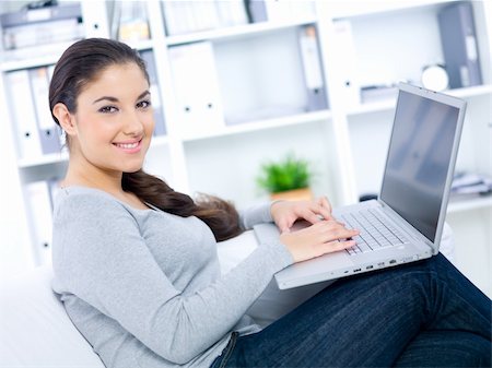 Young woman sitting on couch and working on laptop Stock Photo - Budget Royalty-Free & Subscription, Code: 400-04073785