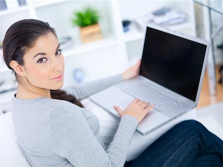 Young woman sitting on couch and working on laptop Stock Photo - Budget Royalty-Free & Subscription, Code: 400-04073787