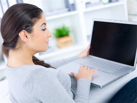Young woman sitting on couch and working on laptop Stock Photo - Budget Royalty-Free & Subscription, Code: 400-04073789