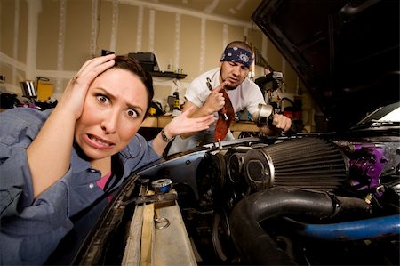 Frustrated woman leaning on car with incompetent male mechanic in background Stock Photo - Budget Royalty-Free & Subscription, Code: 400-04087025