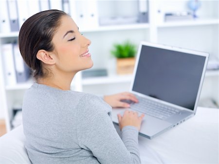 Young woman sitting on couch and working on laptop Stock Photo - Budget Royalty-Free & Subscription, Code: 400-04081242