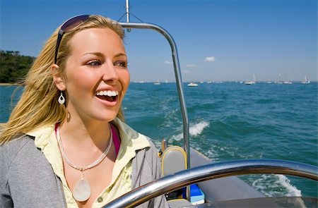 simsearch:400-04082089,k - A stunningly beautiful young woman driving a powerboat and having fun in a beautiful sun drenched coastal location. Stock Photo - Budget Royalty-Free & Subscription, Code: 400-04082089