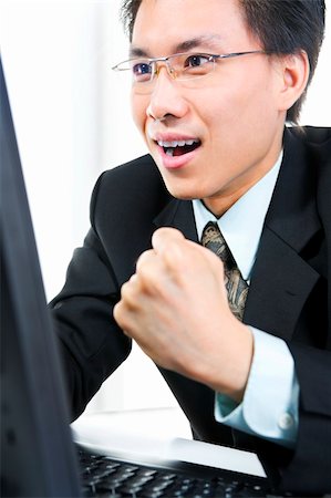 simsearch:400-04639378,k - Side view of a young businessman feels very happy in front of the computer in the office. Stock Photo - Budget Royalty-Free & Subscription, Code: 400-04082379