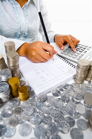 A woman working on accounting using calculator, with many coin stacks around her. South east Asian coins used here. Stock Photo - Budget Royalty-Free & Subscription, Code: 400-04082405