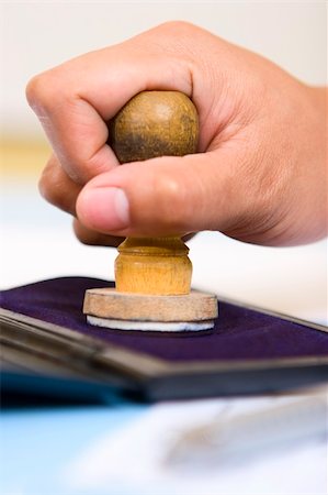 simsearch:400-04082460,k - A hand is pressing a stamp on the stamp pad (ink pad), shot taken from side. Stock Photo - Budget Royalty-Free & Subscription, Code: 400-04082458