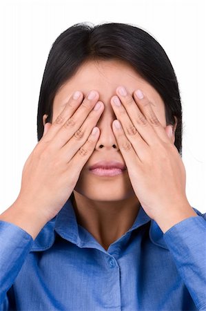 A woman closes her eyes tightly using her hands. This is one series with "No hear" and "No speak". Shoot against very bright white screen as background that separates her naturally from it. Foto de stock - Super Valor sin royalties y Suscripción, Código: 400-04082715