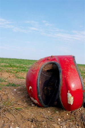 Broken red helmet lying on a field Fotografie stock - Microstock e Abbonamento, Codice: 400-04095702