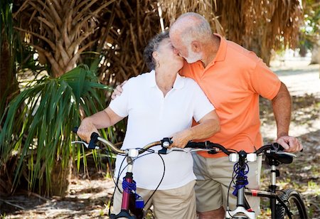 simsearch:400-04336549,k - Active senior couple taking a breat from cycling to kiss each other. Fotografie stock - Microstock e Abbonamento, Codice: 400-04097474