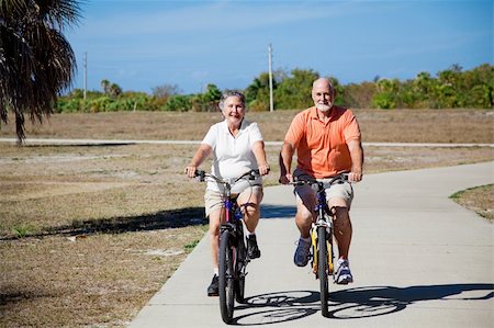 Happy active senior couple riding their bicycles. Foto de stock - Super Valor sin royalties y Suscripción, Código: 400-04097477