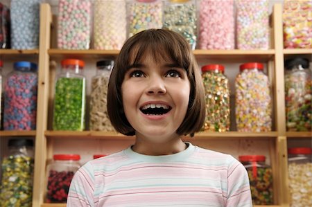 spoiled for choice - young girl smiling in awe at rows of sweets Stock Photo - Budget Royalty-Free & Subscription, Code: 400-04097623