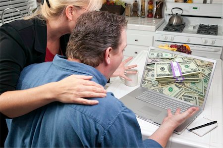 simsearch:400-05129327,k - Couple In Kitchen Using Laptop to Earn or Win Money. Screen can be easily used for your own message or picture. Picture on screen is my copyright as well. Stock Photo - Budget Royalty-Free & Subscription, Code: 400-04092472