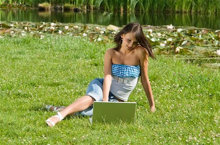 simsearch:6109-06003526,k - cute brunette in casual dress standing alone on the grass and working on the computer Stock Photo - Budget Royalty-Free & Subscription, Code: 400-04092812