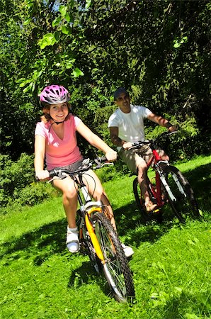 parent and teen bikes - Teenage girl and her father riding bicycles in summer park Stock Photo - Budget Royalty-Free & Subscription, Code: 400-04093554