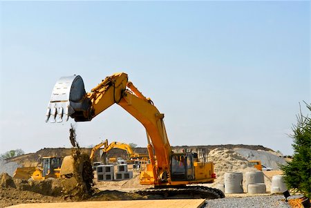simsearch:400-05326745,k - Yellow bulldozer machines digging and moving earth at construction site Fotografie stock - Microstock e Abbonamento, Codice: 400-04093604