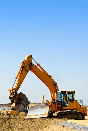 simsearch:400-05326745,k - Yellow bulldozer machines digging and moving earth at construction site Foto de stock - Royalty-Free Super Valor e Assinatura, Número: 400-04093607