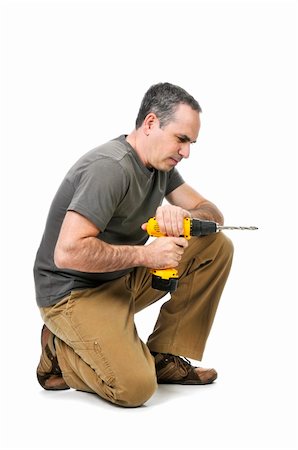 simsearch:400-08054637,k - Kneeling handyman pushing on his cordless drill Stock Photo - Budget Royalty-Free & Subscription, Code: 400-04093663