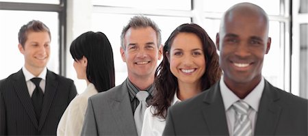 Business man looking at camera with group in background Photographie de stock - Aubaine LD & Abonnement, Code: 400-04106009