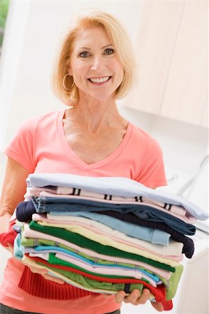 simsearch:640-03260502,k - Woman Carrying Folded Up Laundry Stock Photo - Budget Royalty-Free & Subscription, Code: 400-04106163