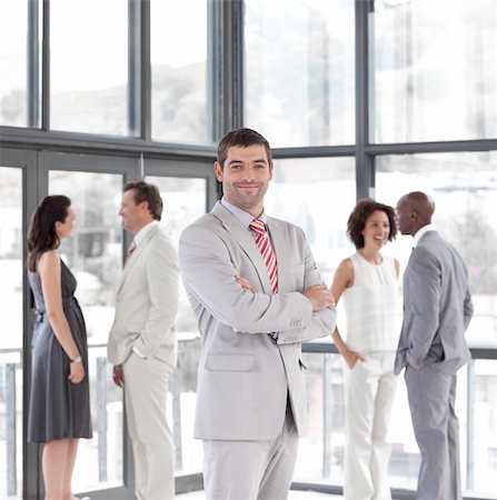 simsearch:400-04113098,k - Attractive standing businessman looking at the camera with his team in the background Stock Photo - Budget Royalty-Free & Subscription, Code: 400-04106936