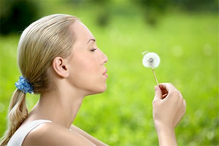 simsearch:400-04107729,k - The blonde sits in park on a grass with a dandelion in hands Stock Photo - Budget Royalty-Free & Subscription, Code: 400-04107729