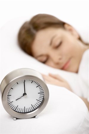 The girl sleeps in white bed against an alarm clock Stock Photo - Budget Royalty-Free & Subscription, Code: 400-04107840