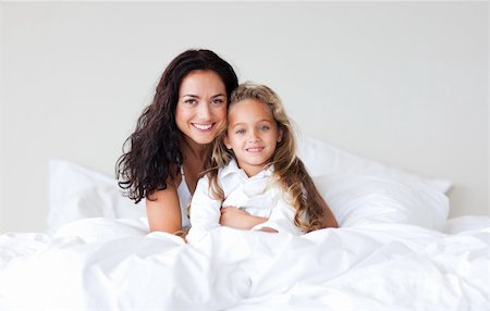 Young Mother and her daughter on bed smiling at camera Stock Photo - Budget Royalty-Free & Subscription, Code: 400-04108153