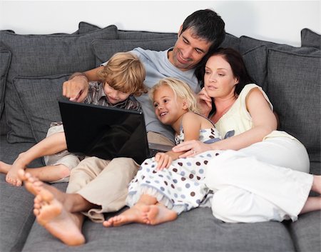 simsearch:400-04044134,k - Young Family on a sofa with laptop Fotografie stock - Microstock e Abbonamento, Codice: 400-04108259
