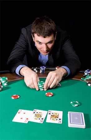 simsearch:400-06136085,k - Stylish man in black suit making bet in the casino Fotografie stock - Microstock e Abbonamento, Codice: 400-04108551
