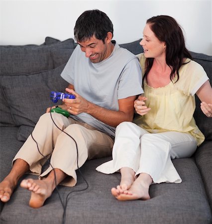 simsearch:400-05059261,k - Young Couple on Sofa Playing Video Games Stock Photo - Budget Royalty-Free & Subscription, Code: 400-04108750