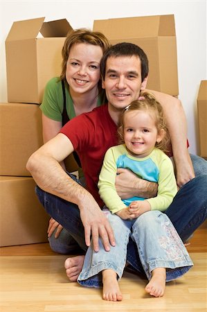 Happy family sitting in on the floor with cardboard boxes in their new home Stock Photo - Budget Royalty-Free & Subscription, Code: 400-04102584