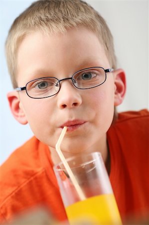 Child sipping orange juice through straw. Stock Photo - Budget Royalty-Free & Subscription, Code: 400-04114171