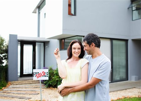 family with sold sign - Young lovely couple saling their house Photographie de stock - Aubaine LD & Abonnement, Code: 400-04114641