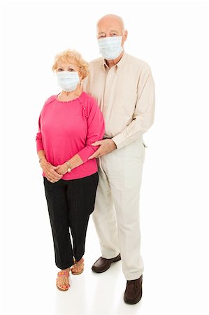 Worried senior couple wearing face masks to protect against flu epidemic.  Isolated on white. Foto de stock - Super Valor sin royalties y Suscripción, Código: 400-04114745