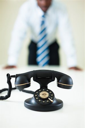 hesitant afro-american businessman staring at the phone Stock Photo - Budget Royalty-Free & Subscription, Code: 400-04115043