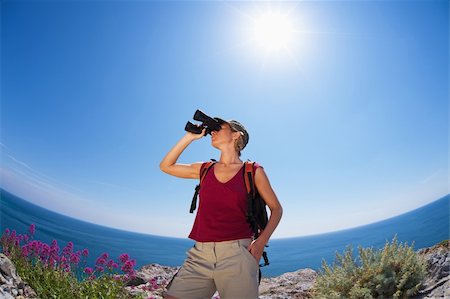 simsearch:400-04043242,k - young blonde woman hiking watching through binoculars. Copy space Photographie de stock - Aubaine LD & Abonnement, Code: 400-04115050