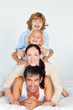 simsearch:400-05749479,k - Family having fun in bed looking at the camera Foto de stock - Royalty-Free Super Valor e Assinatura, Número: 400-04116349