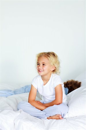 Little girl sitting in bed with copyspace on the top Stock Photo - Budget Royalty-Free & Subscription, Code: 400-04116411